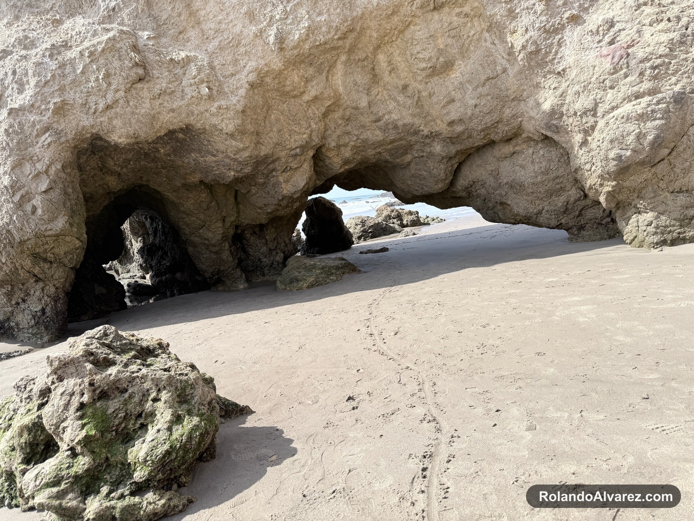 Natural rock arch opening toward the ocean at El Matador State Beach