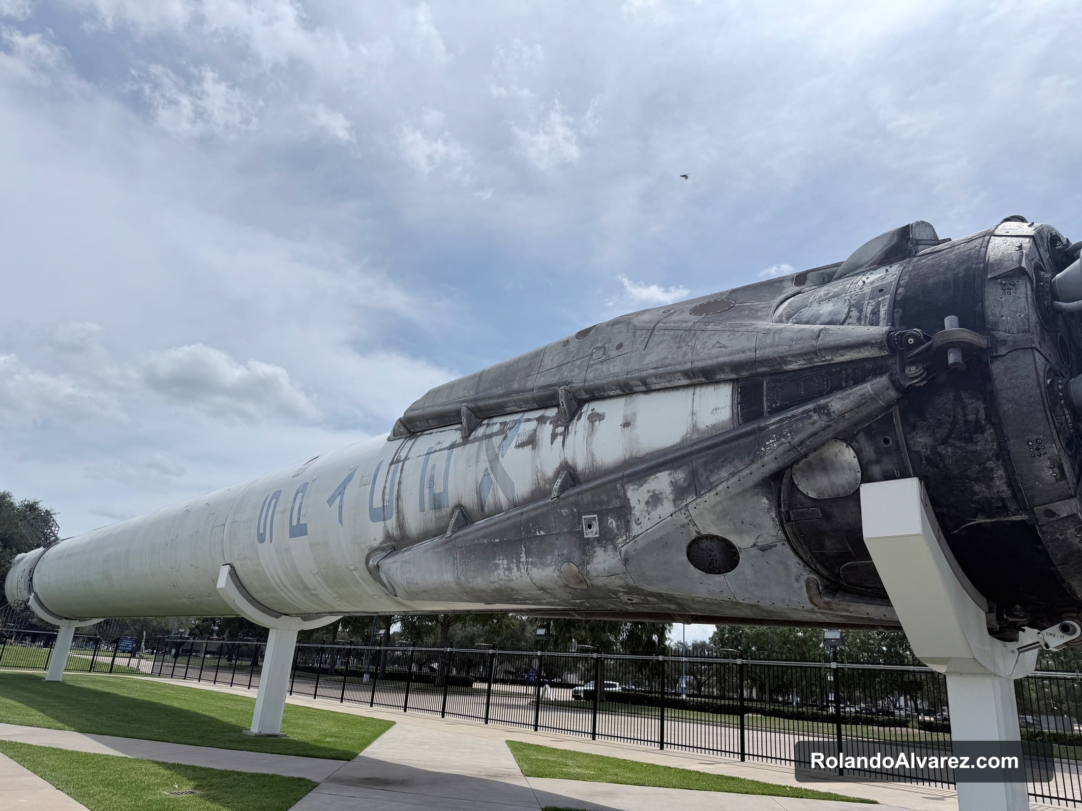 A weathered flown rocket displayed outdoors at Space Center Houston