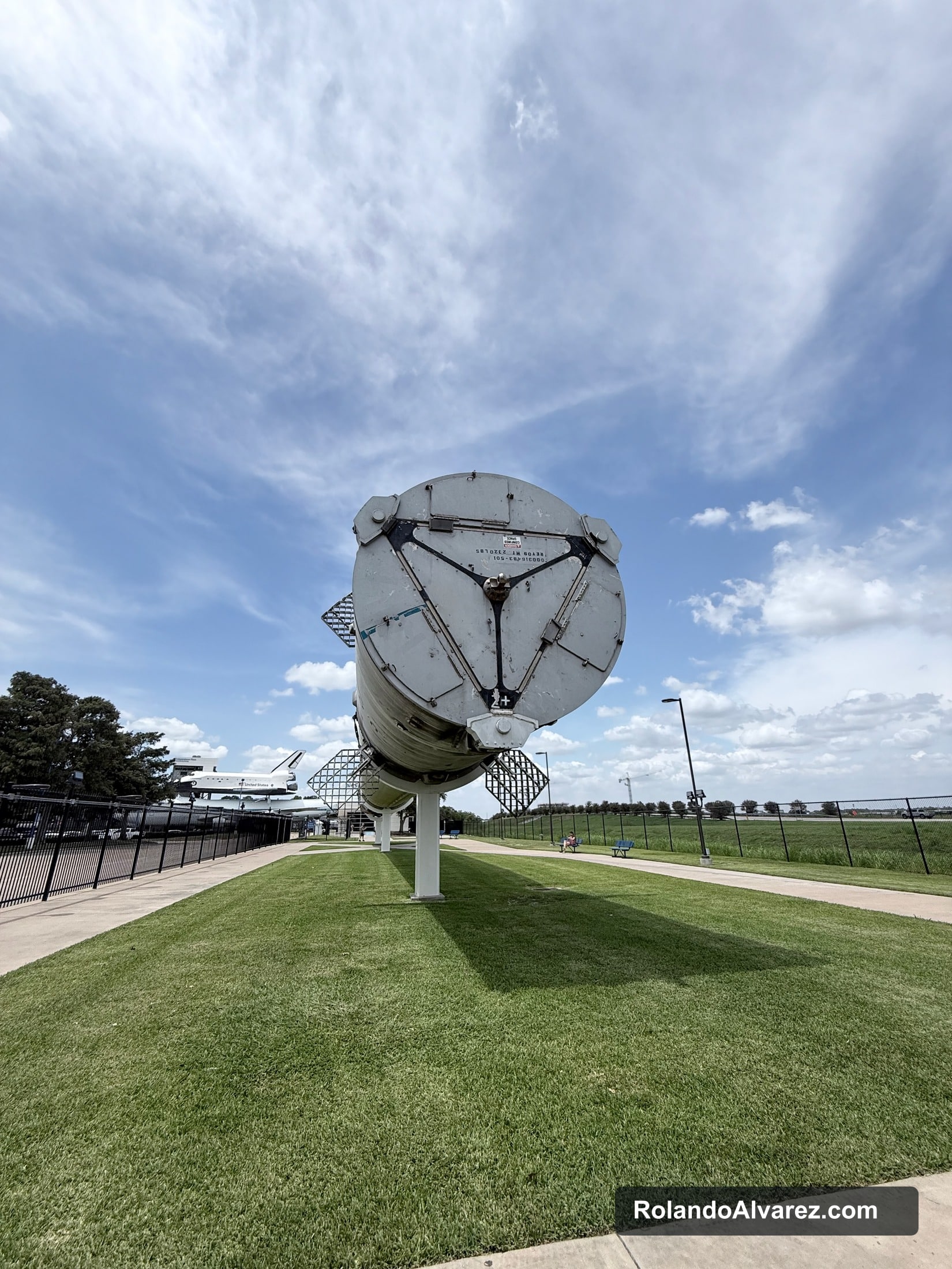 The circular end of a large rocket stage displayed beneath a blue sky