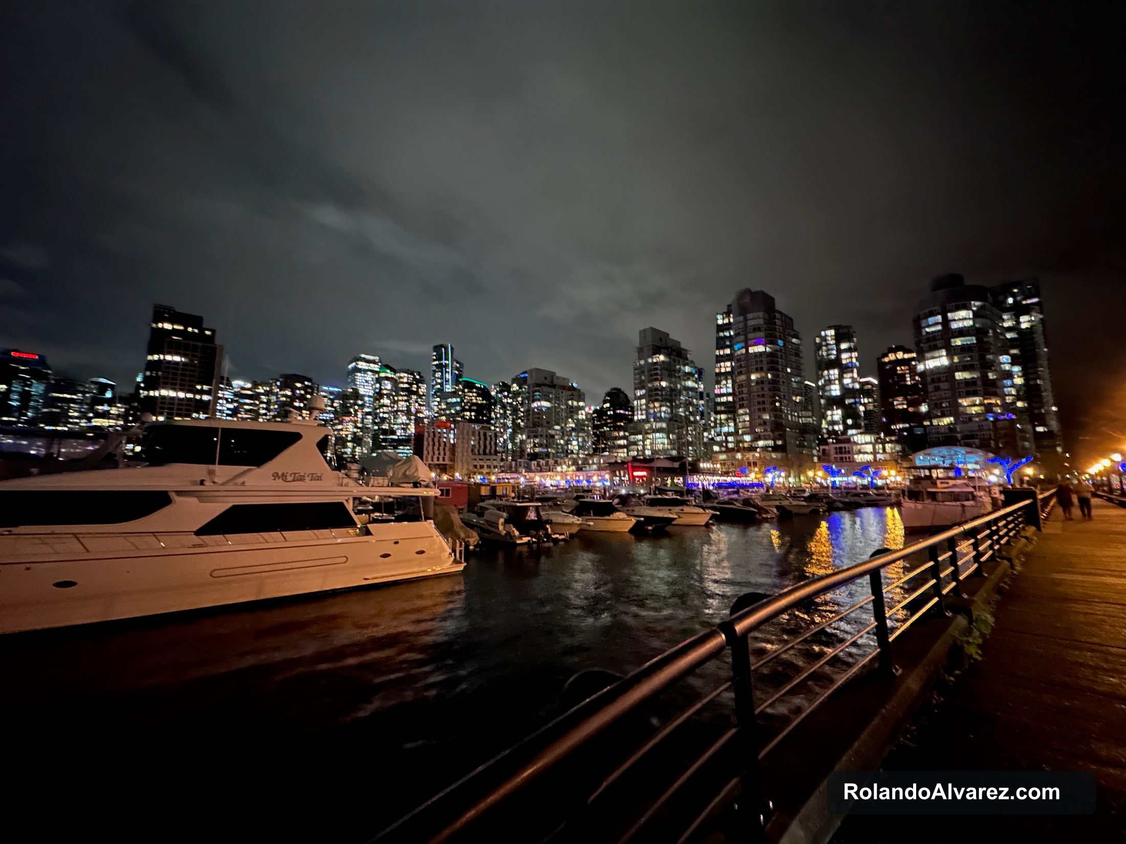 Boats and Vancouver towers illuminated around Coal Harbour Marina at night